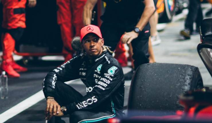 Lewis Hamilton sentado en medio de la pista